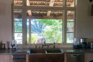 IMG_4064 - Transparent Window Washing Kitchen with a double sink under a large window; view of trees and patio outside the window.